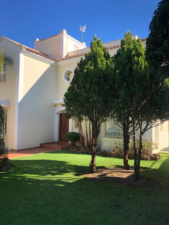 una casa blanca con dos árboles en el patio en VILLA BONITA, en Torremolinos