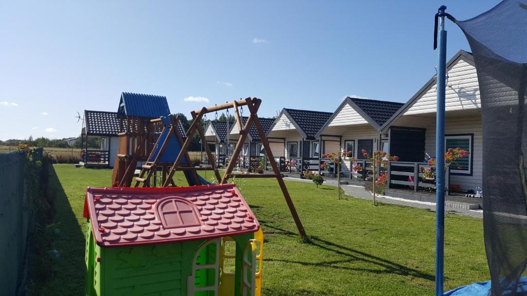 a playground with a swing set in a yard at Błękitna Laguna in Rusinowo