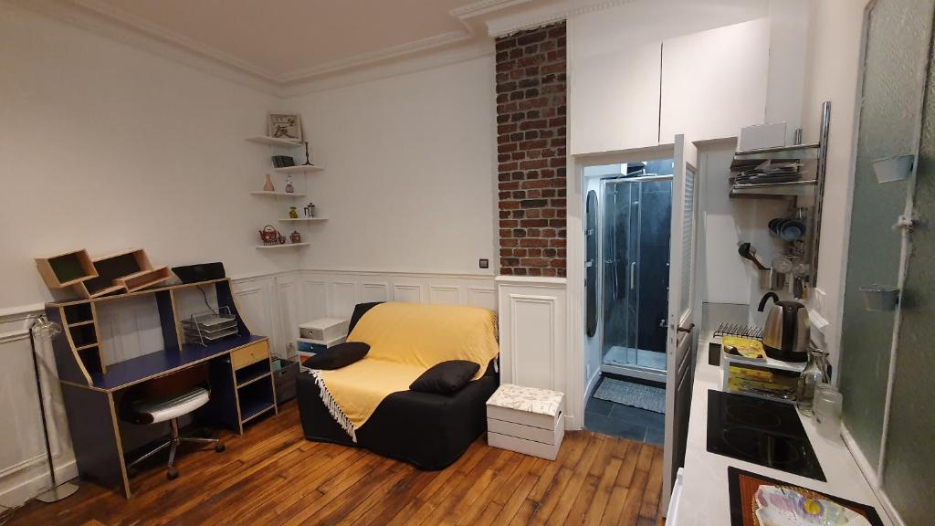 Cette petite chambre comprend un bureau et un lit. dans l'établissement Studio 16m2 dans immeuble Hausmannien, à Paris
