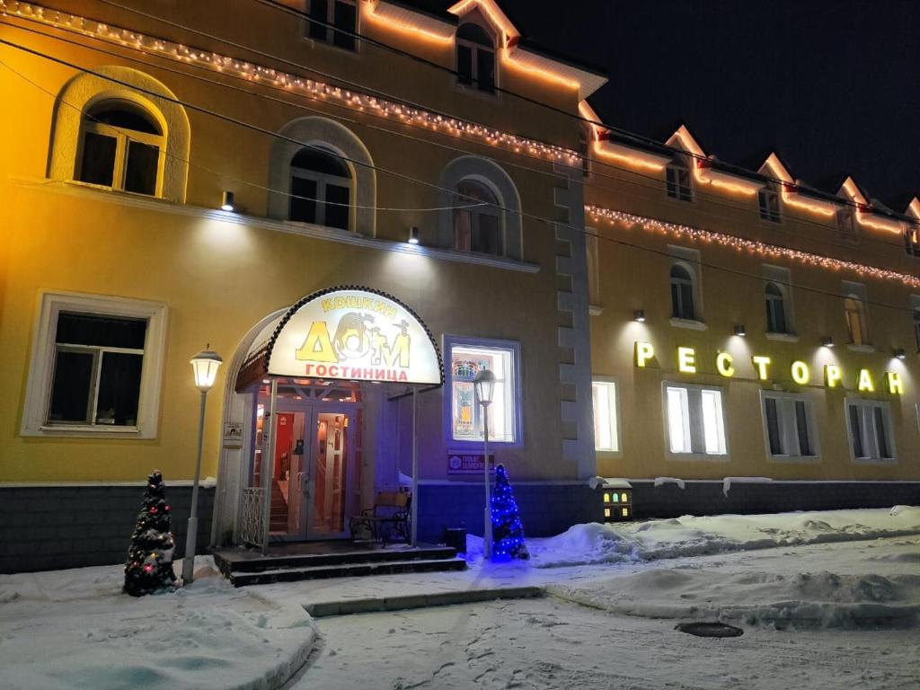 un hôtel avec des arbres de Noël devant un bâtiment dans l'établissement Koshkin Dom, à Mychkine