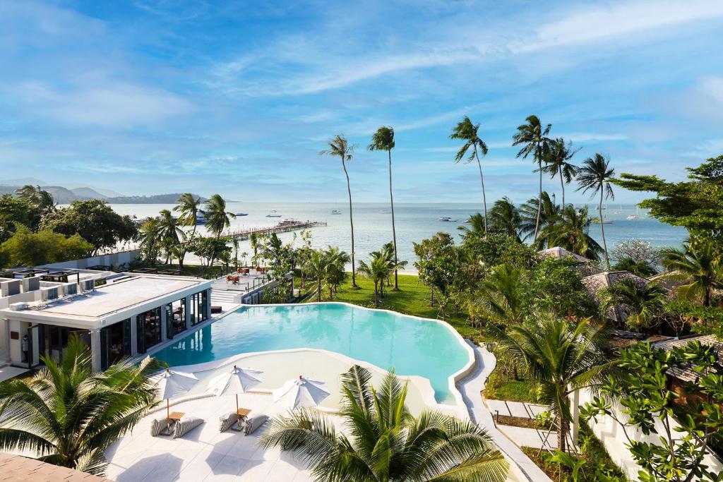 an aerial view of a resort with a swimming pool and the ocean at U Samui in Bang Rak Beach