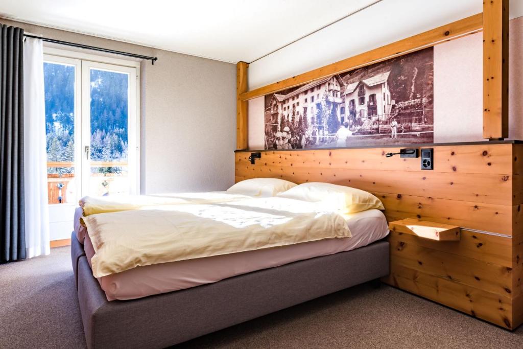 a bedroom with a large bed with a wooden wall at Hôtel du Glacier in Champex