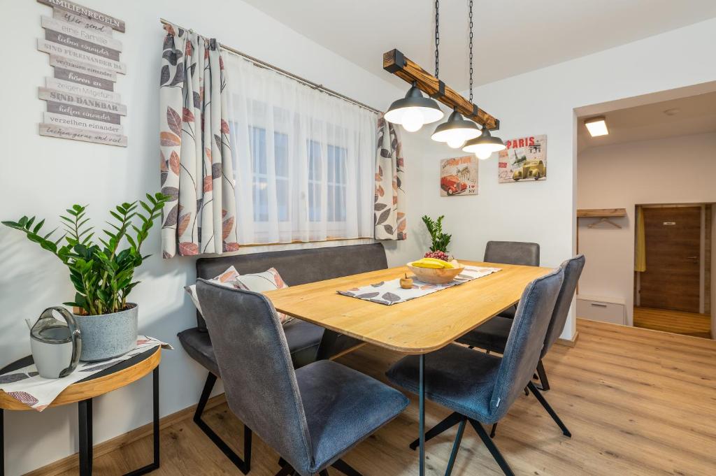 a dining room with a wooden table and chairs at Ferienappartement Kammhuberhof in Pruggern
