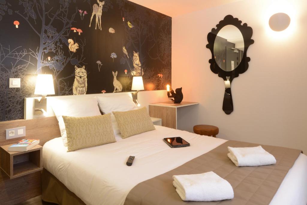 1 dormitorio con 1 cama grande y espejo en la pared en Hotel Arc-En-Ciel Colmar Contact Hotel, en Colmar