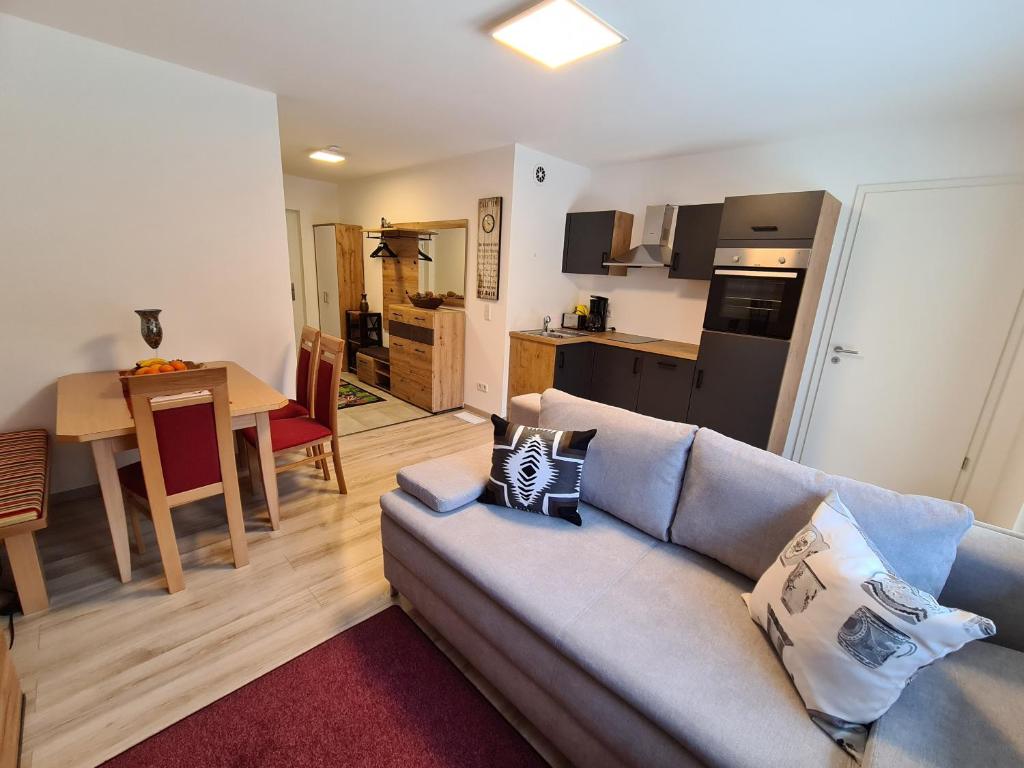 ein Wohnzimmer mit einem Sofa und einer Küche in der Unterkunft Apart Bubendorfer in Lermoos