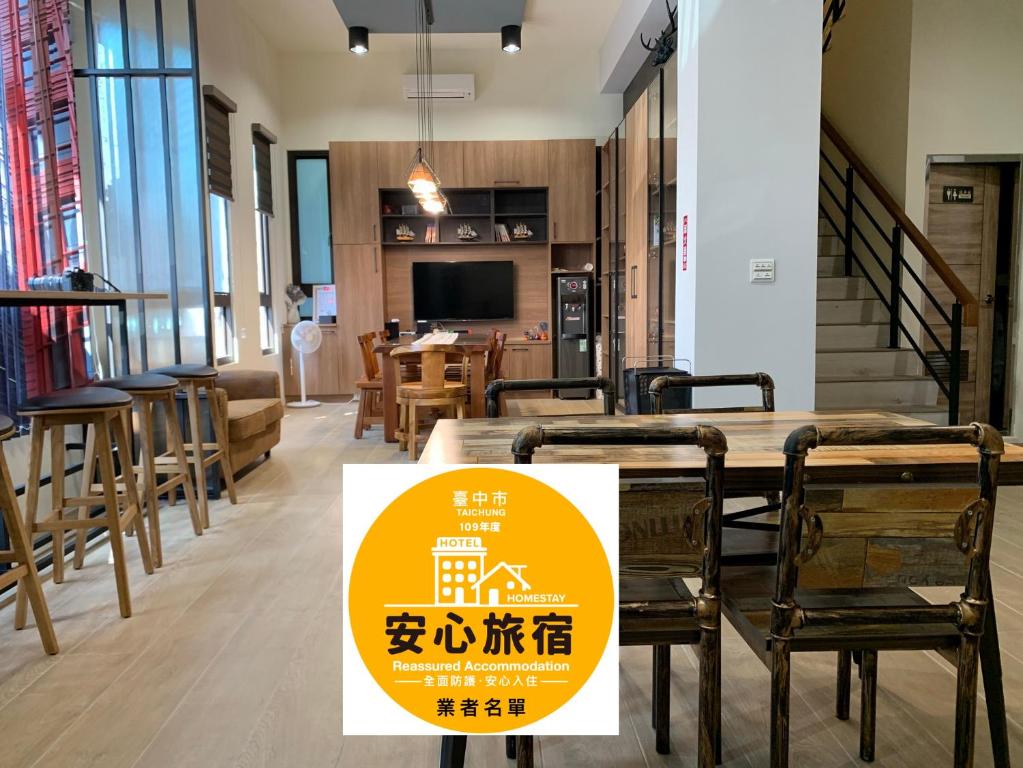 un restaurante con mesa, sillas y un cartel en WT BnB Taichung, en Houli