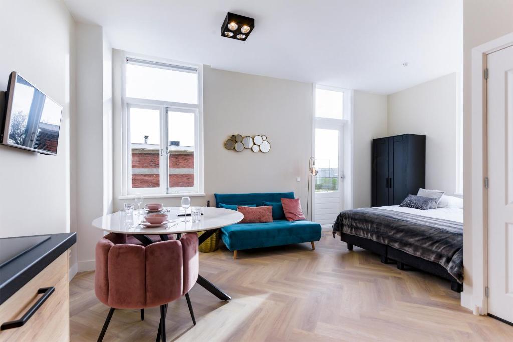 1 dormitorio con 1 cama y 1 mesa en una habitación en Novallure Short Stay Apartments en Leidschendam