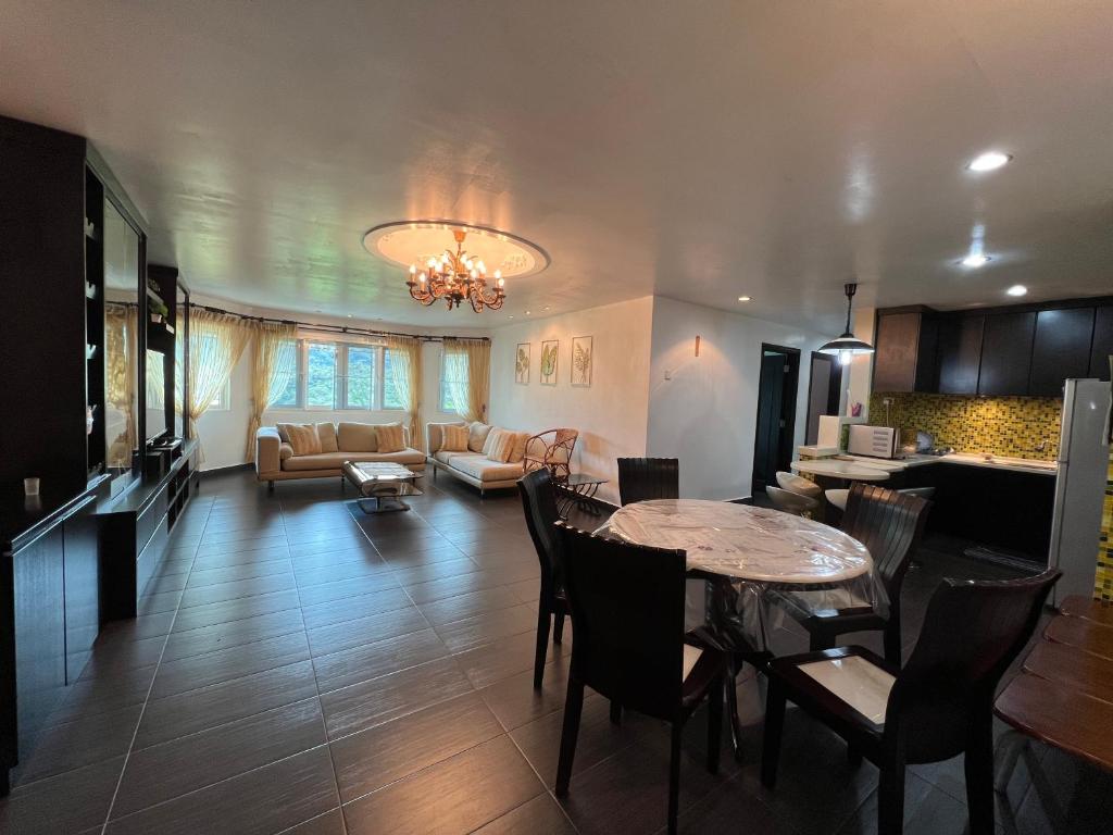 cocina y sala de estar con mesa y sillas en MAGICAL HOMESTAY CAMERON HIGHLANDS en Cameron Highlands