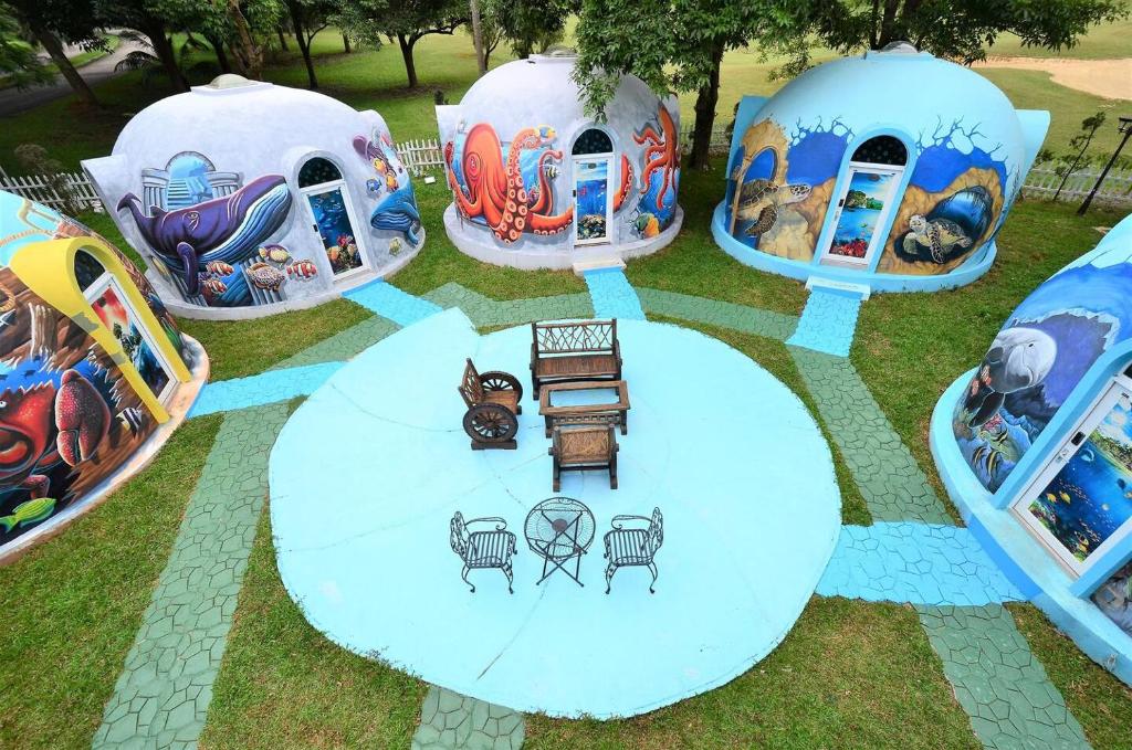 a group of domes with a table and chairs in the grass at Atlantis Dome Villa Lot 3108 in Kampong Alor Gajah