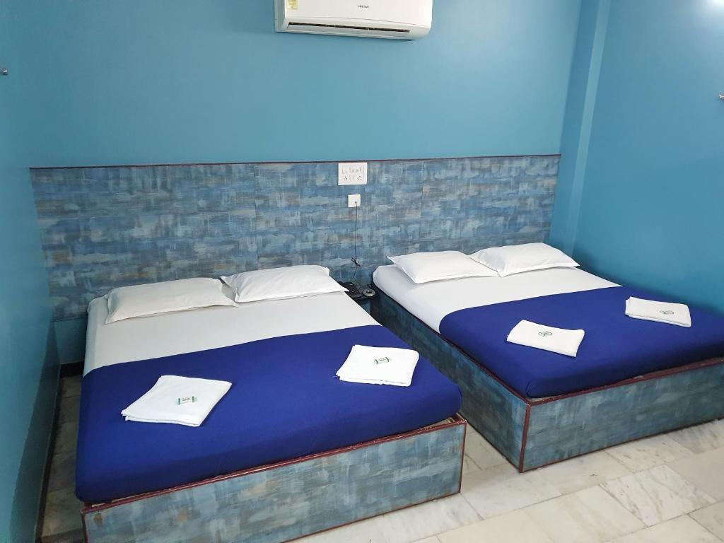 two beds in a room with blue walls at SM MANSION near Harbour & High court in Chennai