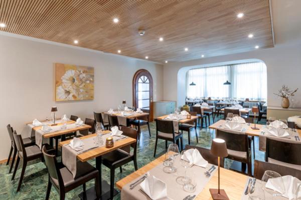 a dining room with tables and chairs in a restaurant at Hotel Bellevue in San Bernardino