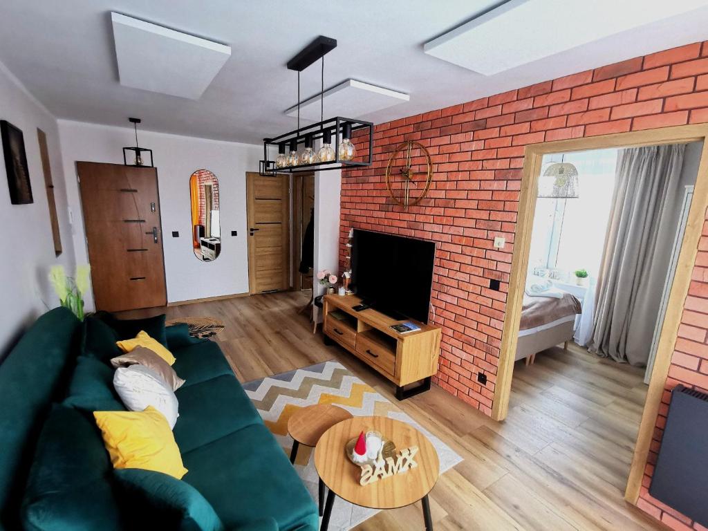 Televízia a/alebo spoločenská miestnosť v ubytovaní APARTAMENT NA WZGÓRZU