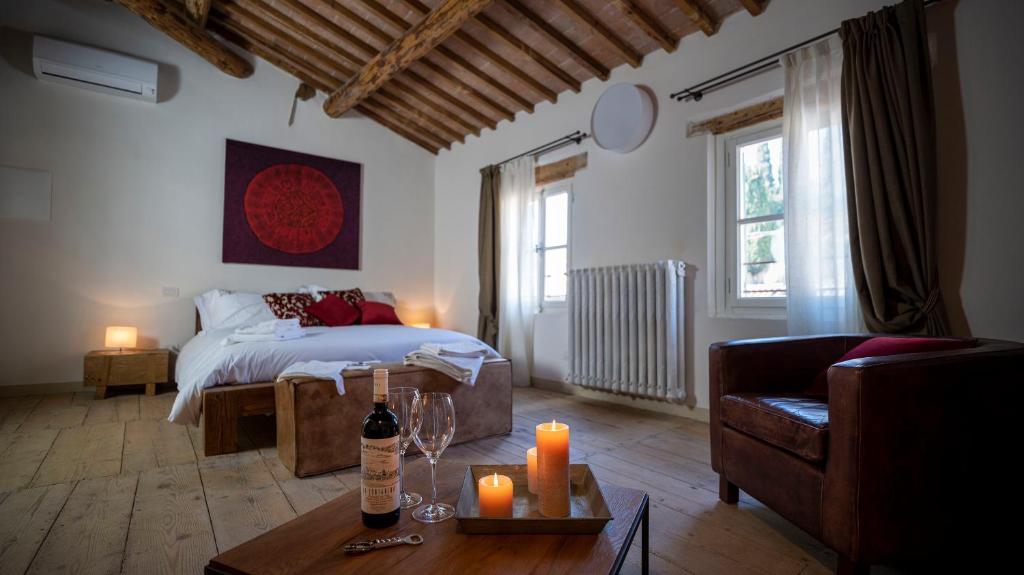 uma sala de estar com uma cama e uma mesa com velas em Locanda Dell'Oleificio em Mezzane di Sotto