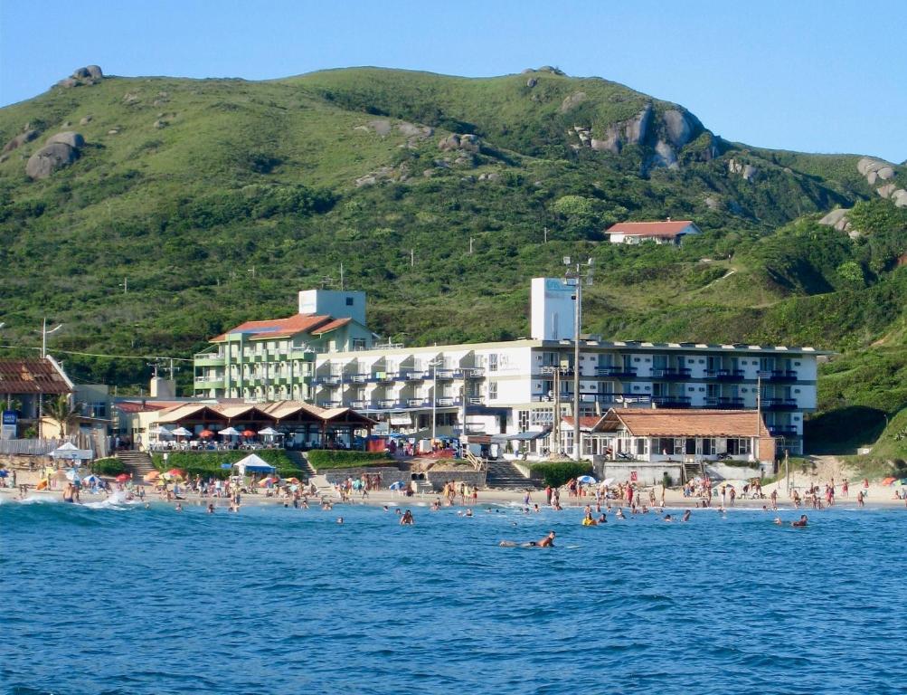 un grupo de personas en una playa en el agua en Cris Hotel en Florianópolis