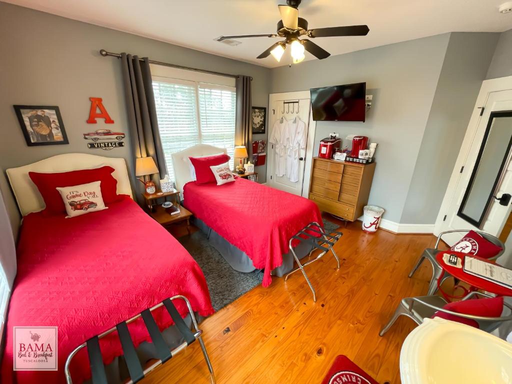 um quarto com duas camas com capas vermelhas em Bama Bed and Breakfast - Sweet Home Alabama Suite em Tuscaloosa