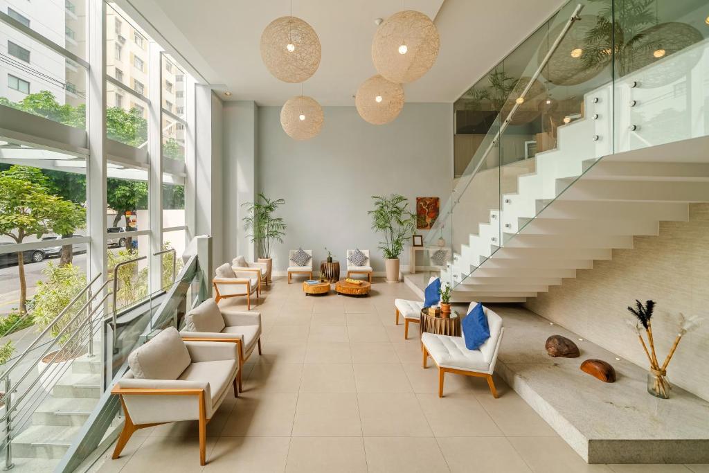 un vestíbulo con sofás, sillas y escaleras en Matiz Niterói Design Hotel, en Niterói