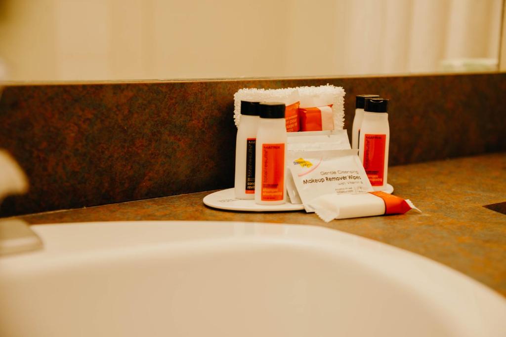 a bathroom counter with toiletries and a bath tub at Super 8 by Wyndham Revelstoke BC in Revelstoke