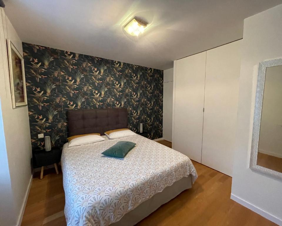 sypialnia z łóżkiem i ścianą w obiekcie Chez Cathy et Léo w mieście Dinan