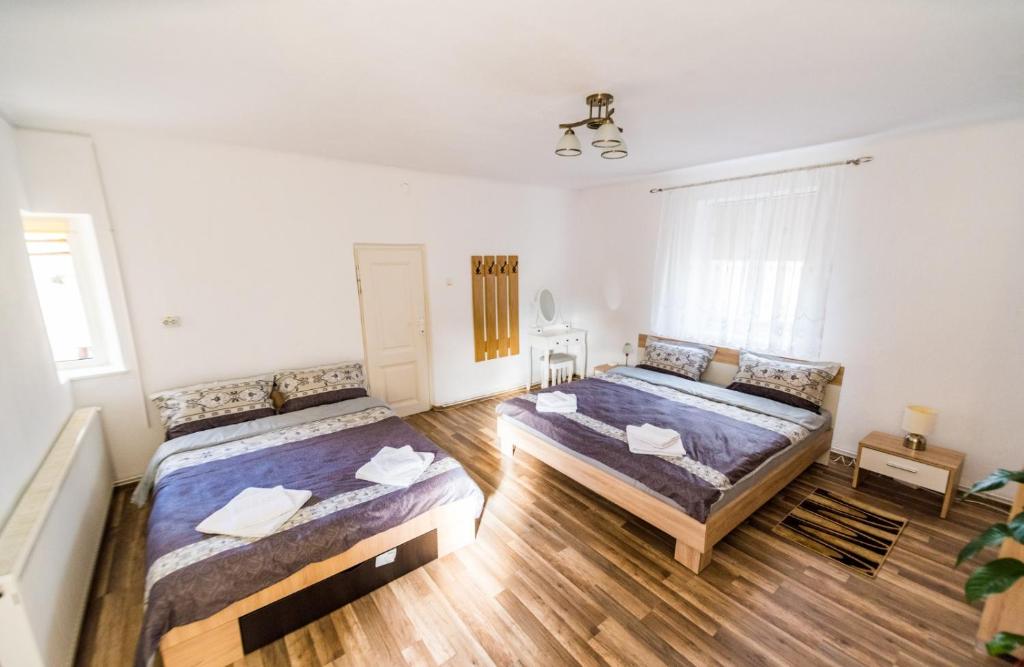 twee bedden in een kamer met houten vloeren bij Casa Aldem in Sibiu