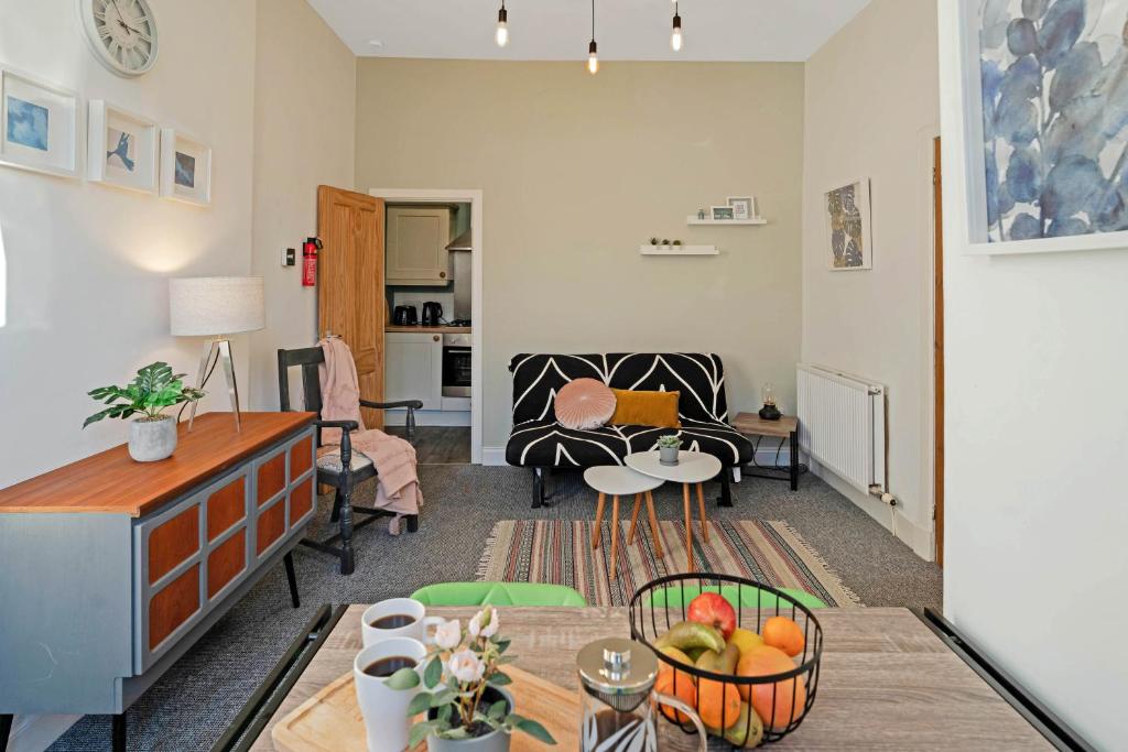 una sala de estar con una mesa con fruta en una cesta en Cozy with Character Logie Green Central Main Door Flat, en Edimburgo