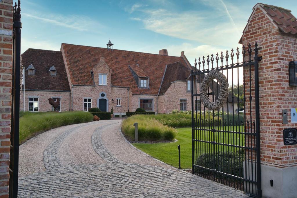 ブラーケルにあるBoutique Hotel De Brakelhoenの錬鉄門付煉瓦造りの家の入口