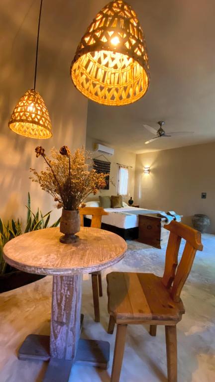 a table with a vase of flowers on top of it at Hotel Boutique Refugio 41 in Valladolid