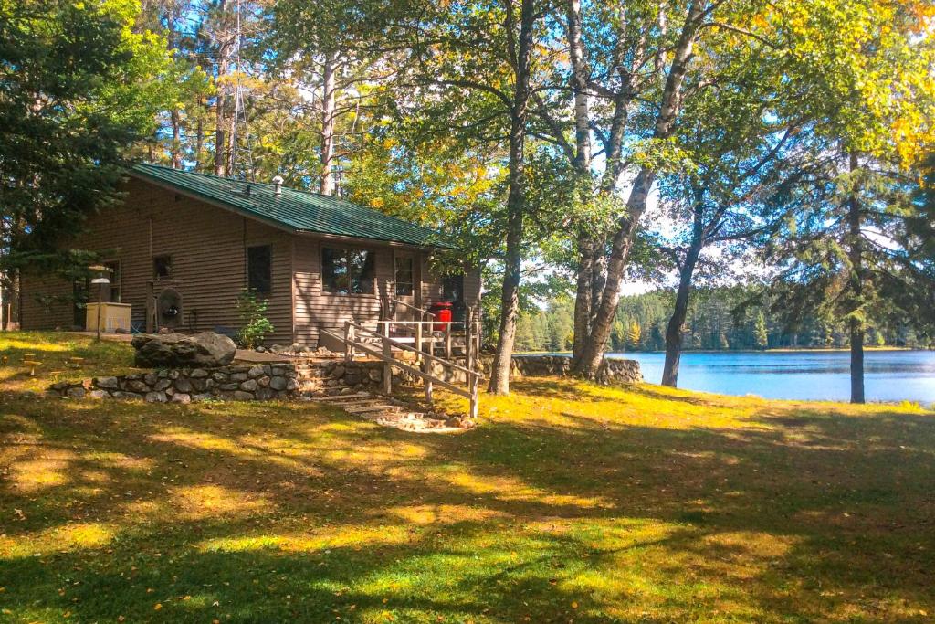 una baita di tronchi nel bosco vicino a un lago di Hotter's Cabin a Sayner