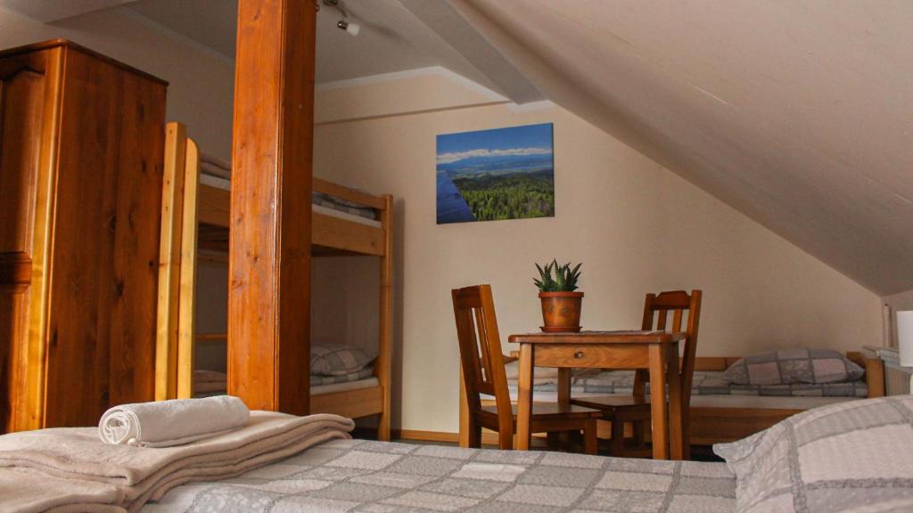 ein Schlafzimmer mit einem Bett, einem Tisch und Stühlen in der Unterkunft Gorczański Kącik in Ochotnica Dolna