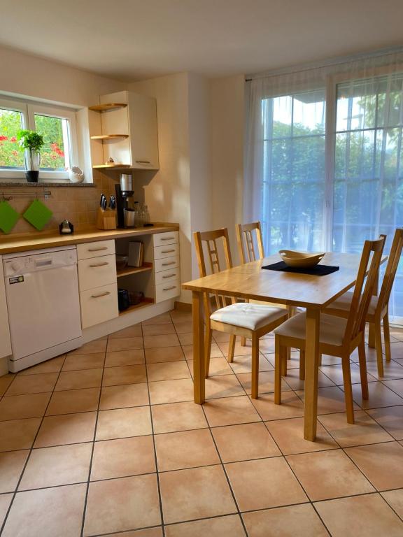 a kitchen with a wooden table and chairs and a table and a table at Ferienwohnung Am Gießbach 15 in Bodman-Ludwigshafen