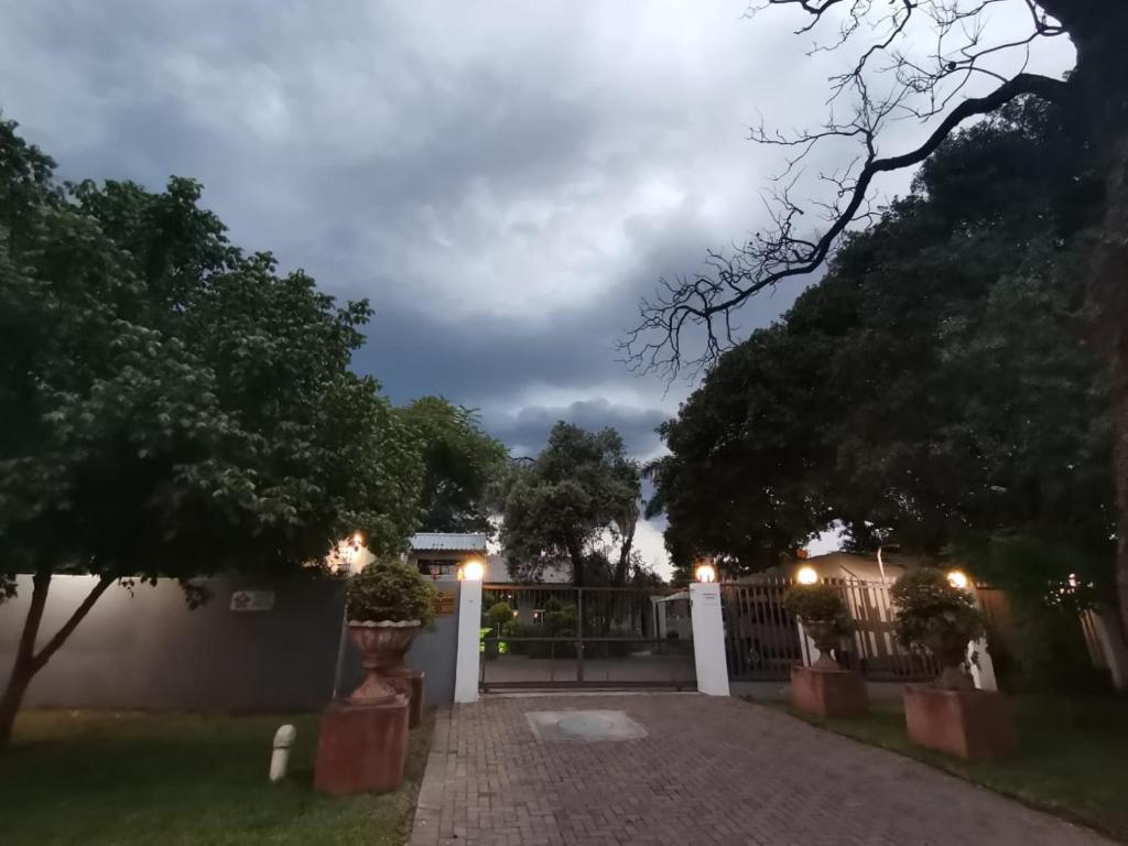 a driveway in front of a fence at night at Bono Luxury Guesthouse in Rustenburg