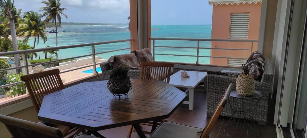 a balcony with a table and chairs and the ocean at ilococo in Sainte-Anne