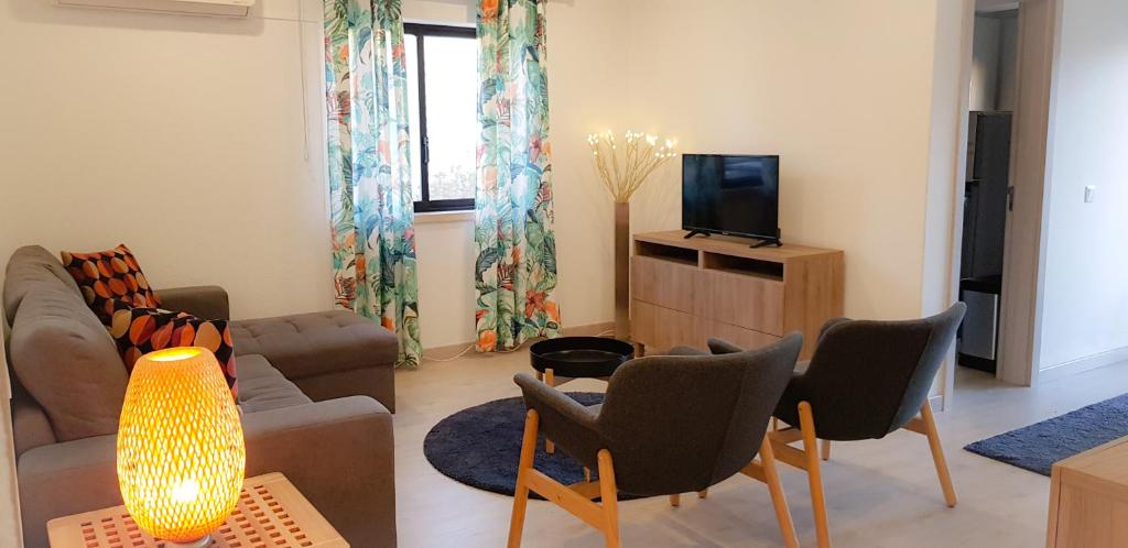 a living room with a couch and a tv at Apartamento T2 Club Amarílis - Portimão in Portimão