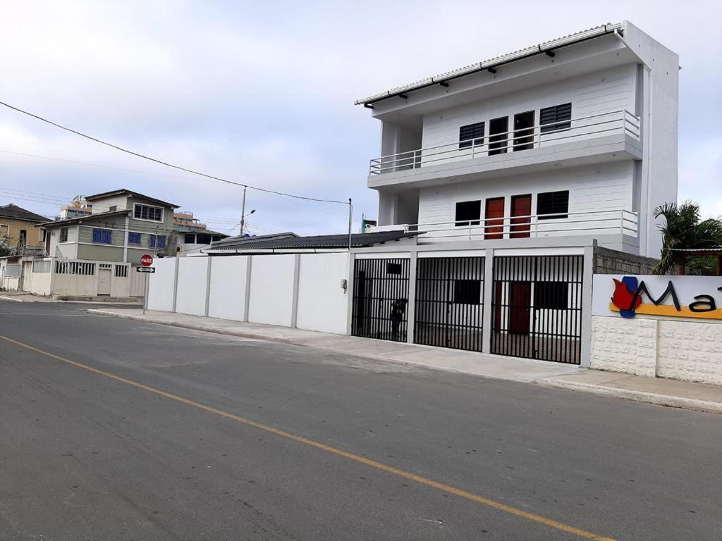 a white building on the side of a street at Suites del Pacífico in Salinas
