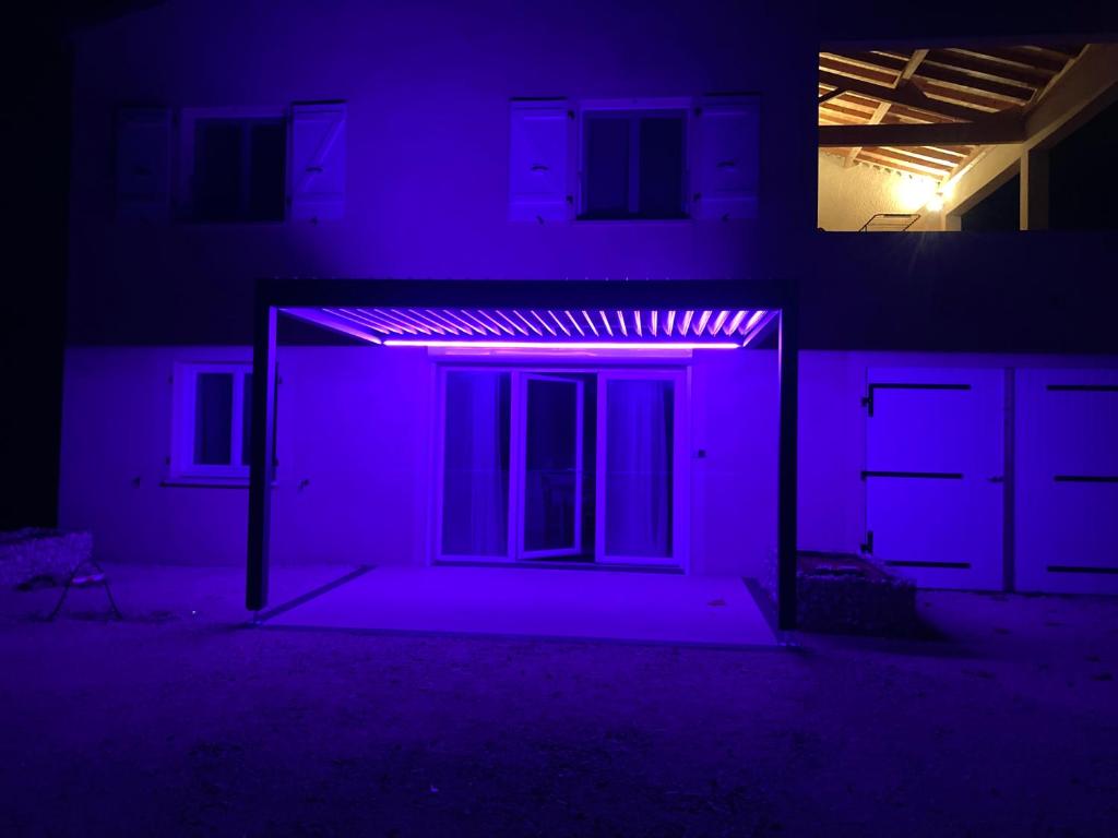 una casa con una luz morada en la oscuridad en Bel appartement en campagne en Grane