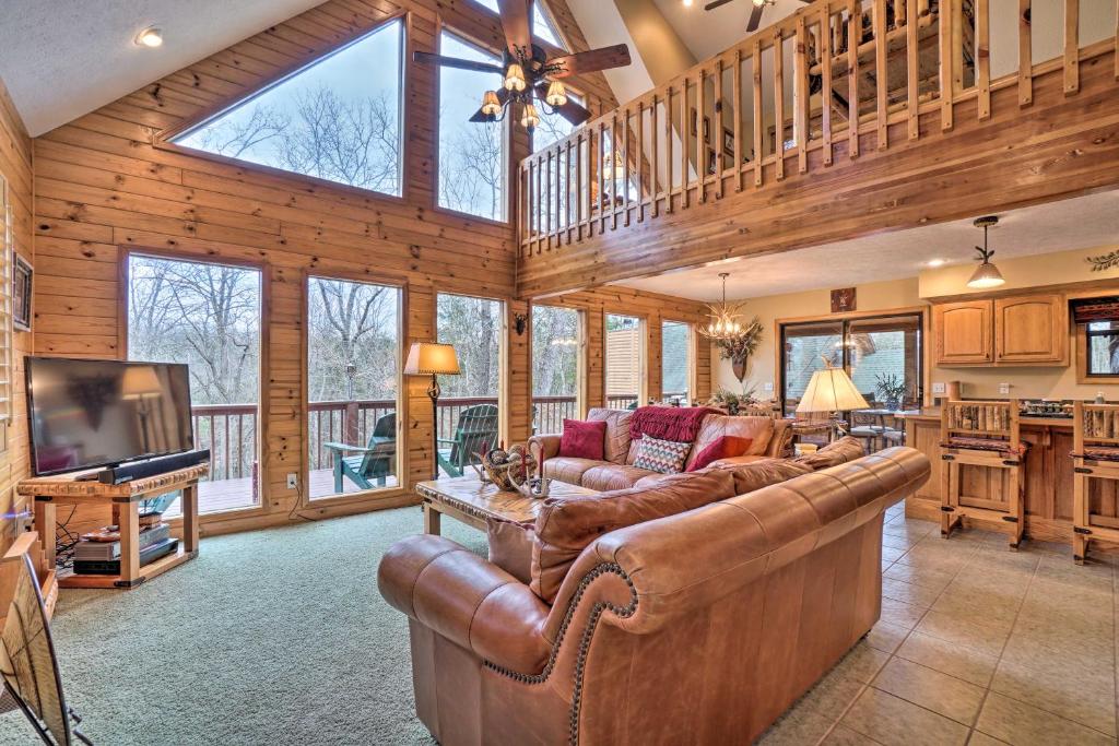 un soggiorno con divano e TV in una casa di Fire Pit and Views Family Cabin on Table Rock Lake a Golden