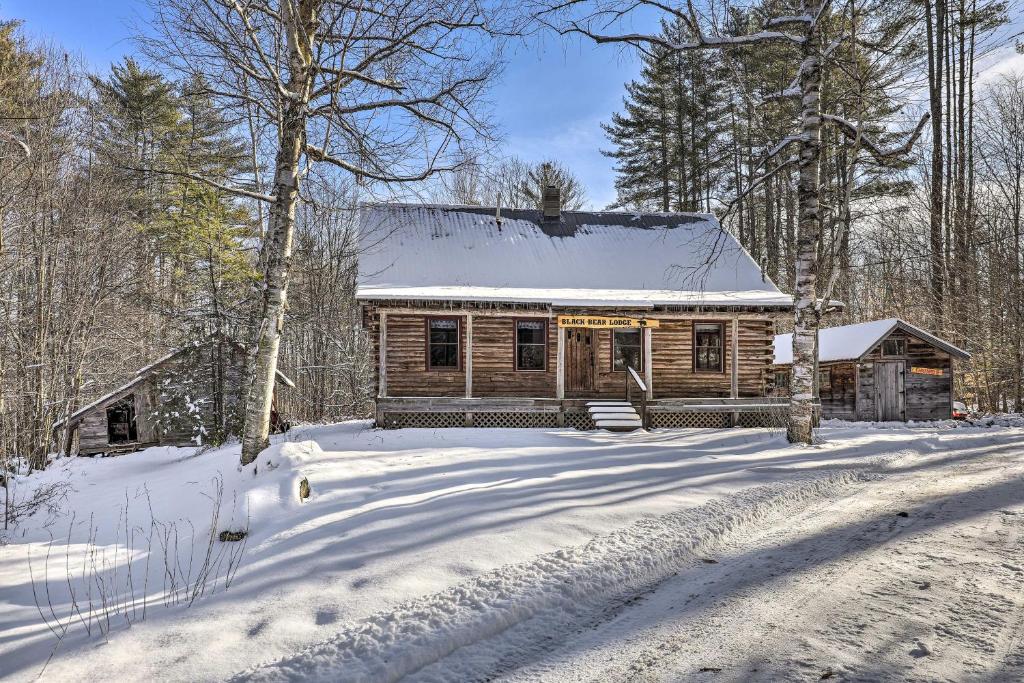 una cabaña de madera en la nieve en el bosque en Black Bear Lodge A Rural White Mtns Retreat, 