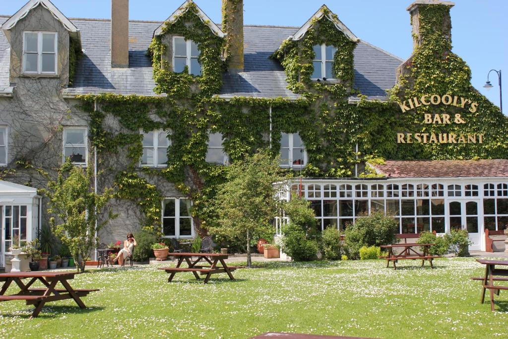 a building with picnic tables in front of it at Kilcooly's Country House Hotel in Ballybunion
