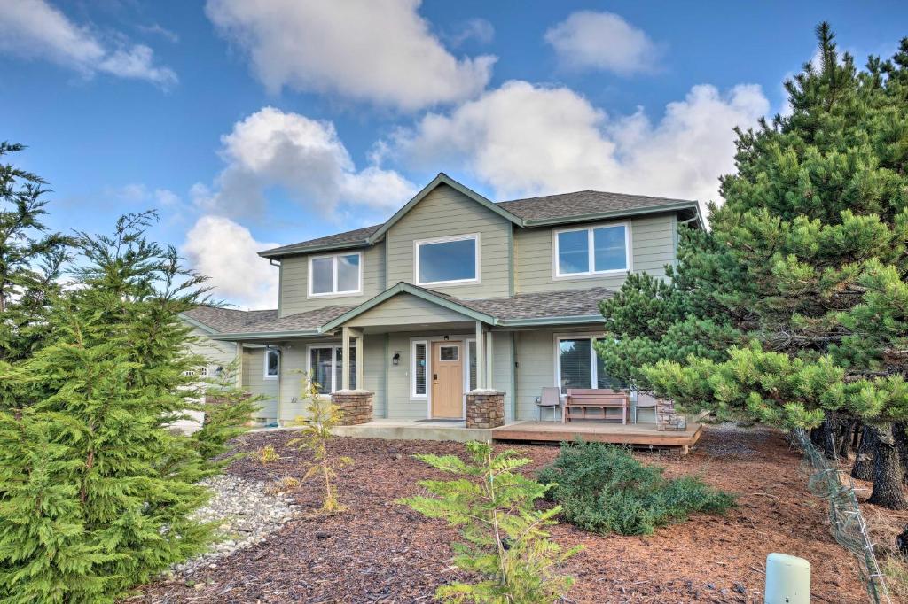 a house with a bench in the front yard at Spacious Bandon Getaway - 2 Blocks to Ocean! in Bandon