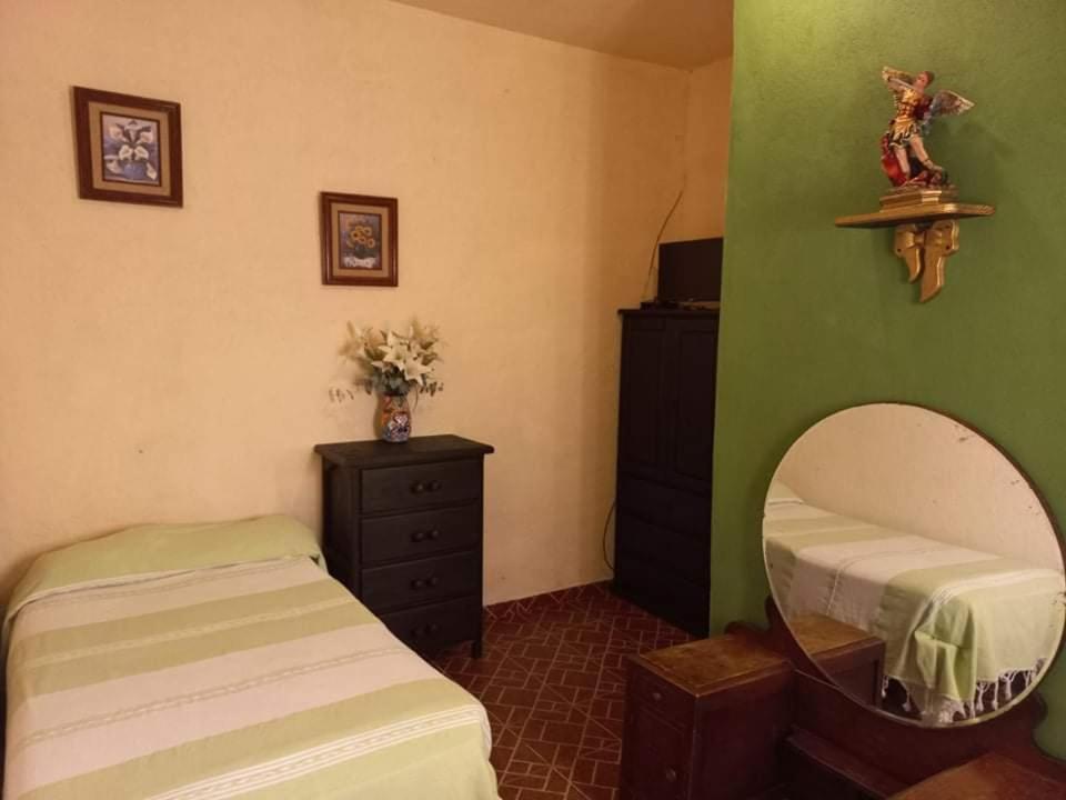 a room with two twin beds and a mirror at Casa Loteria in San Miguel de Allende