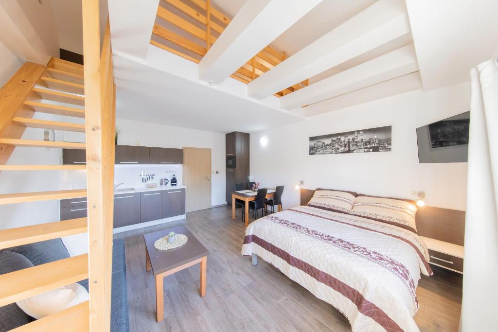 a bedroom with a bed and a staircase in it at Apartmány Sophia 7 in Velké Losiny