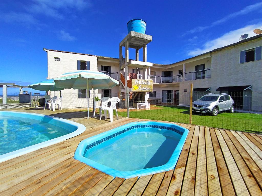 a swimming pool on a deck next to a house at Pousada Colibris in Pinhal