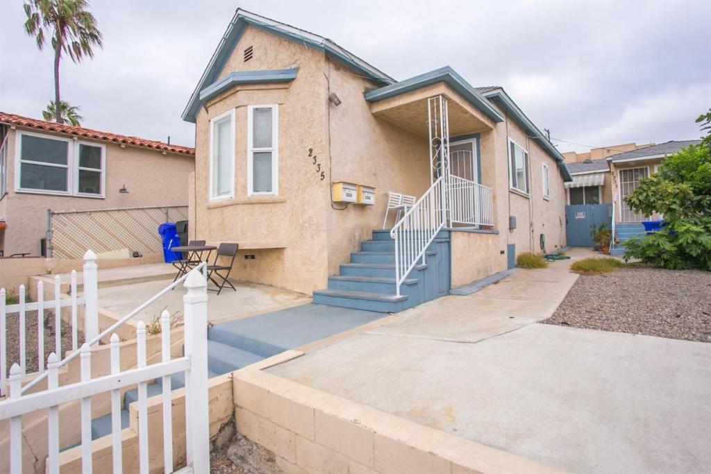 ein Haus mit einem weißen Zaun davor in der Unterkunft 3bd Little Italy Cottage A++ Location in San Diego