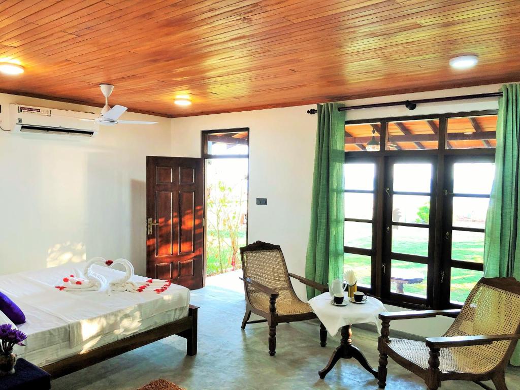 a bedroom with a bed and a table and chairs at Sunflower Beach Resort in Beruwala