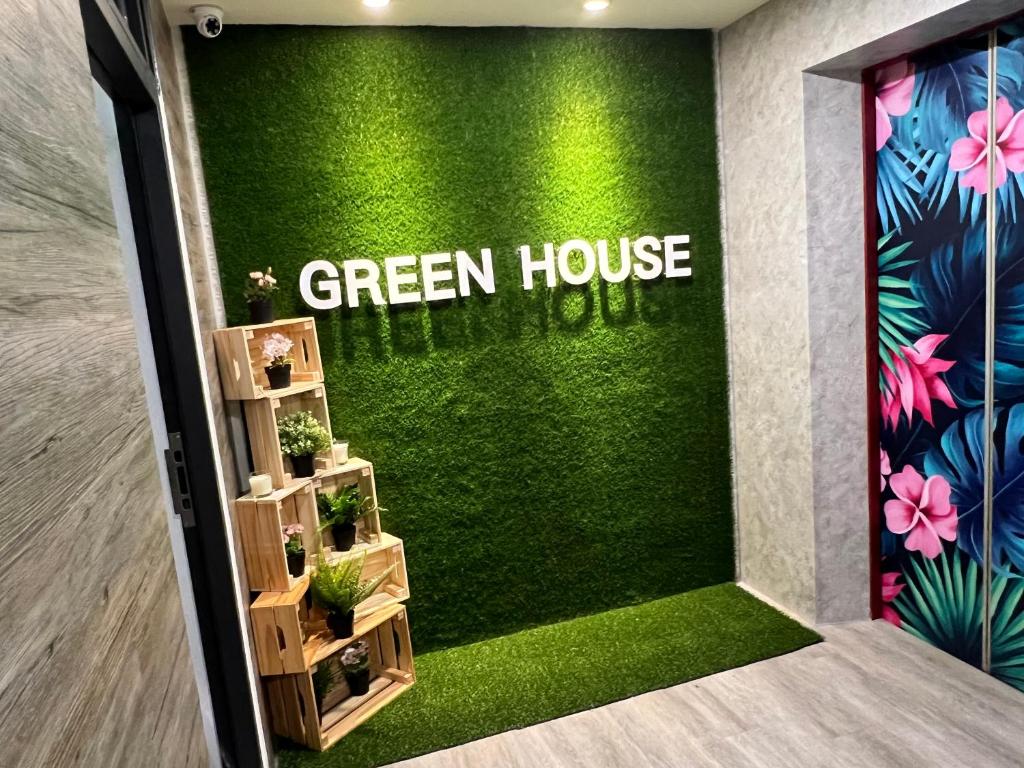 Fengyuan green Self B&B في فنج يوان: مدخل البيت الأخضر بالنباتات على جدار أخضر