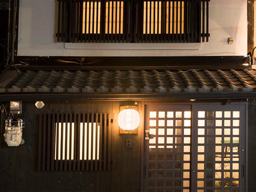 un edificio con una puerta con una luz encendida en Kyomachiya Gion Kanau en Kyoto