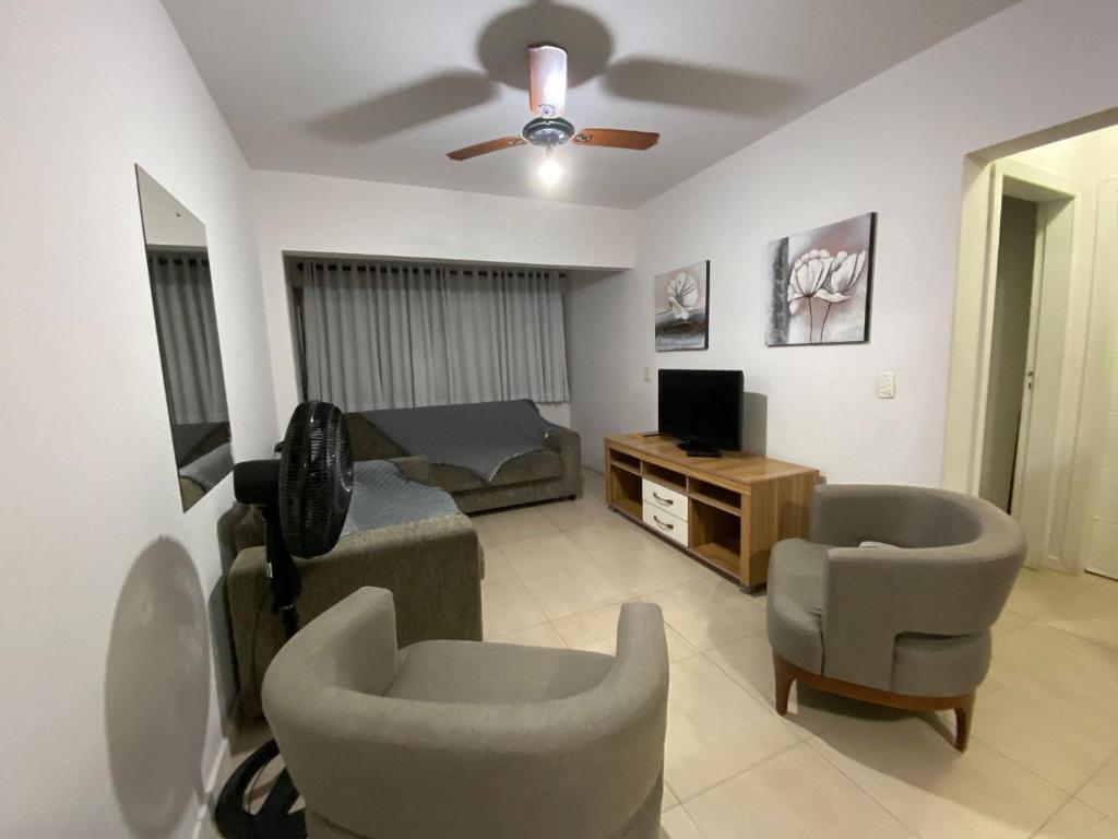 sala de estar con sofá y 2 sillas en Apartamento Avenida Brasil, en Balneário Camboriú