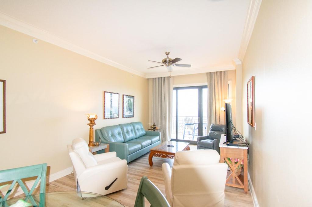 德斯坦的住宿－Emerald Grande III，客厅配有蓝色的沙发和椅子
