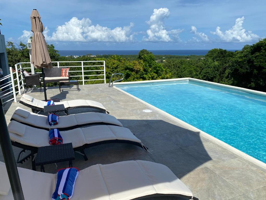 a swimming pool with chairs and an umbrella at RunAway to Tranquility, overlooking the Bay in Runaway Bay