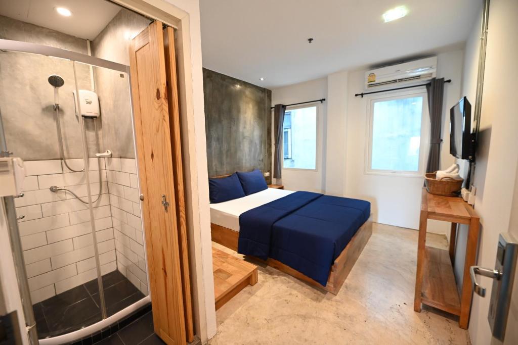 a small bedroom with a bed and a shower at Sribumpen Plus in Bangkok