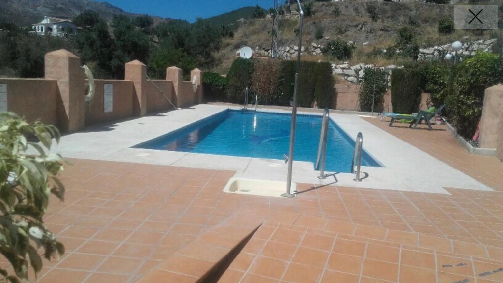 una piscina su un patio in mattoni con di Precioso apartamento en complejo residencial. ad Alcaucín